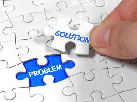 Closeup an male hand holding the jigsaw puzzle solution to the problem missing piece.の写真素材