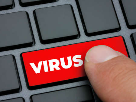 Close up finger pressing red virus key on computer keyboardの写真素材