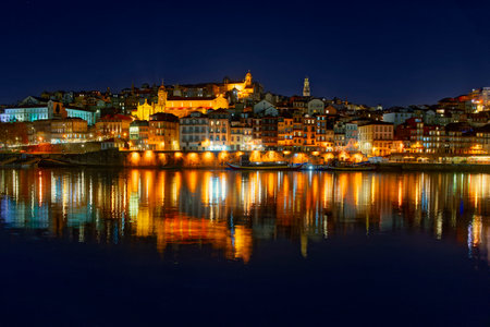 Porto, Portugal old city skyline from across the Douro River at night.