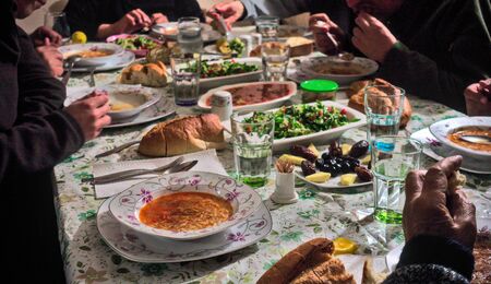 Crowded Turkish Muslim family having iftar together in happiness with delicious vegan food on the tableの写真素材