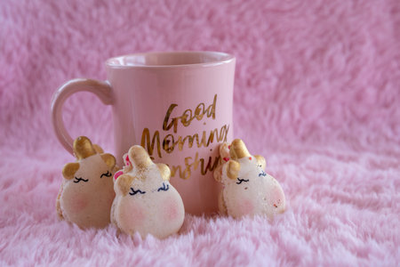 Cup of tea or coffee with unicorn cookies on pink backgroundの写真素材