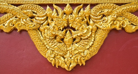 High relief sculpture, gold serpent on the floor of the temple wall. In northern Thailand