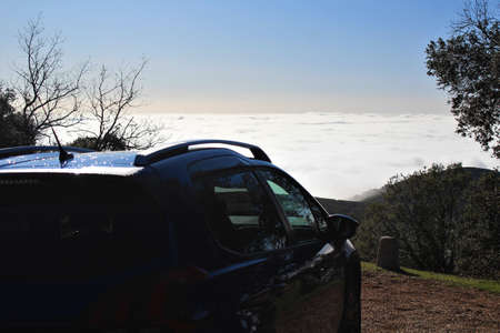 View of foggy and cloudy mountain valley landscape with carの写真素材