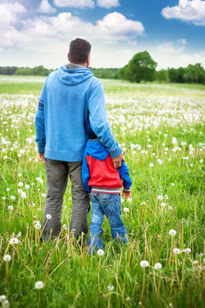 Father and son on dandelion fieldの写真素材