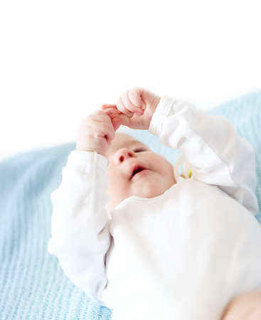 Little baby on blue blanket watching at own fingersの写真素材