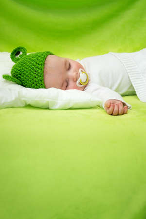 little boy lying on soft green blanketの写真素材