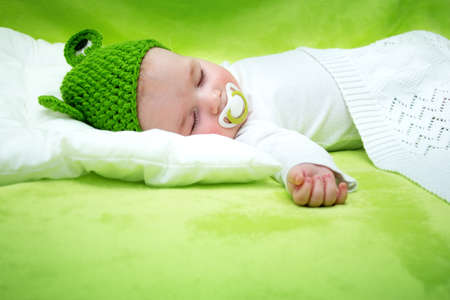little boy lying on soft green blanketの写真素材