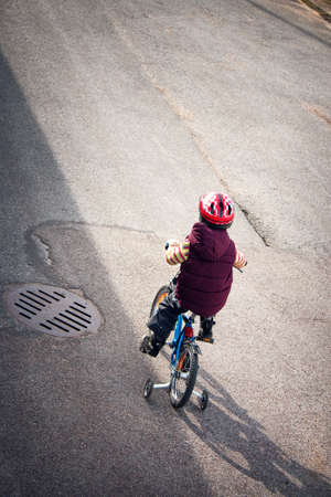 Boy on bike at asphalt road in springの写真素材