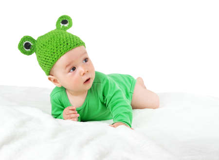 little baby in knitted frog hat on soft blanketの写真素材