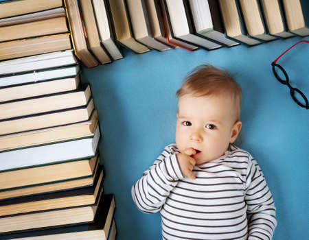 One year old baby among books with spectackleの写真素材