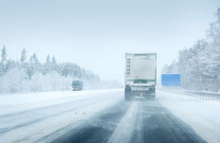 Trucks moving on a motorway in blizzardの写真素材