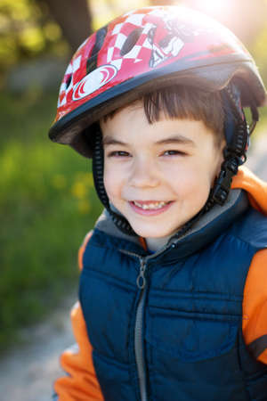 child on bike in the park with dandelions in pleasant sunny spring dayの写真素材