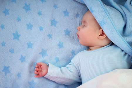 3 month old baby sleeping on blue blanket with stars