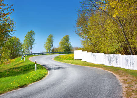 Car on asphalt road in beautiful spring day at countrysideの写真素材