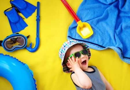 little boy with sunglasses on yellow blanketの写真素材