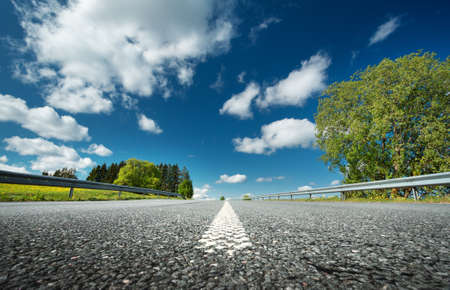 Car on asphalt road in beautiful spring day at countrysideの写真素材