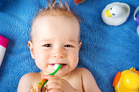 one year old baby lying on towel with washing toolsの写真素材