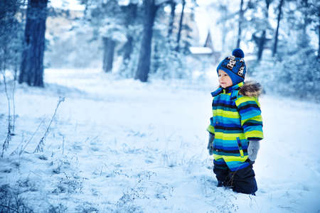 Baby boy smiling at snowfall. Child in winter clothesの写真素材