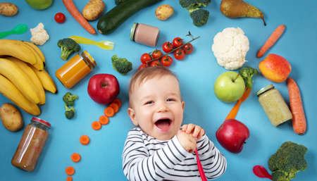 Baby surrounded with fruits and vegetablesの写真素材