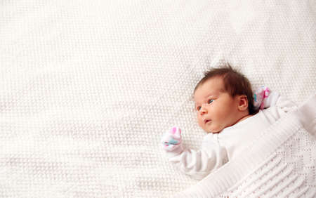 Cute newborn baby girl lying in the bed