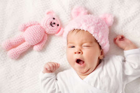 Cute newborn baby girl lying in the bedの写真素材