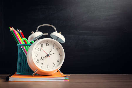 School accessories on the table with blackboard background