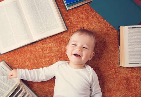 One year old baby with spectackles and booksの写真素材