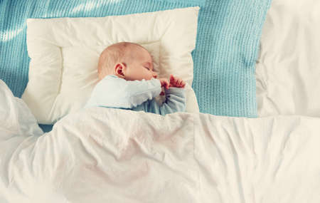 baby sleeping on blue blanketの写真素材