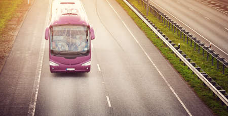 Bus on asphalt road in beautiful summer eveningの写真素材
