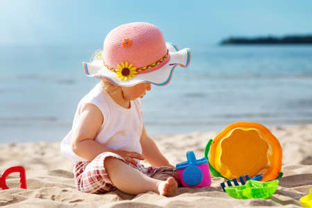 little girl shouting at the sea with bucketの写真素材
