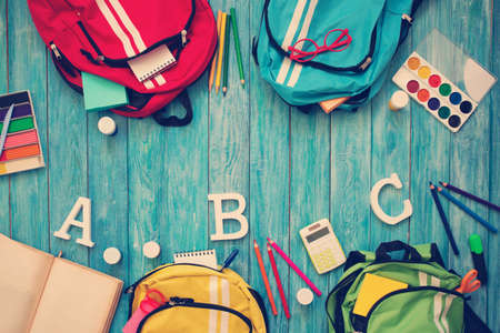 Colourful children schoolbags on wooden floorの写真素材