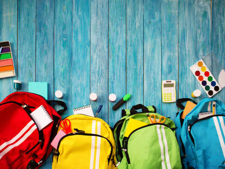Colourful children schoolbags on wooden floorの写真素材