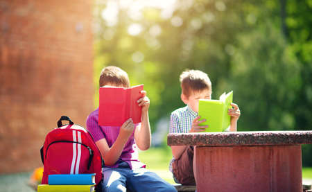 Children with rucksacks standing in the park near schoolの写真素材