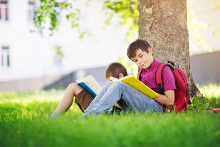 Children with rucksacks standing in the park near schoolの写真素材