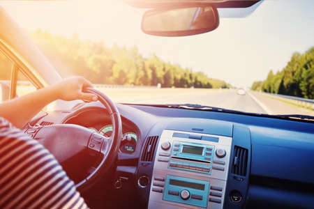 driver driving a car on asphalt road in summerの写真素材