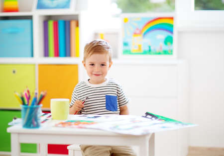 Little child drawing on the paper in roomの写真素材