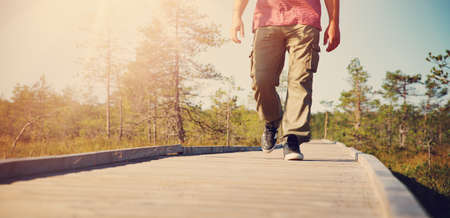 Man walking on wooden walkway in natureの写真素材