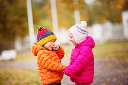 children throwing leaves in beautiful autumnal dayの写真素材