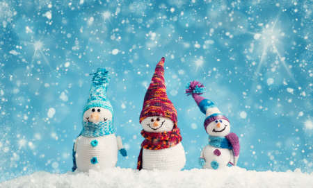 little snowmans on soft snow on blue backgroundの写真素材