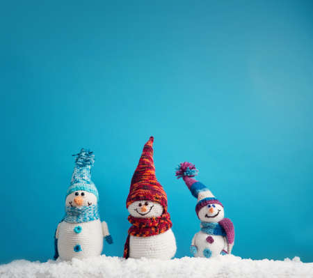 little snowmans on soft snow on blue backgroundの写真素材