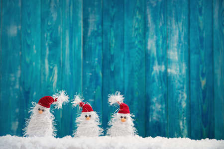 little snowmans on soft snow on blue backgroundの写真素材