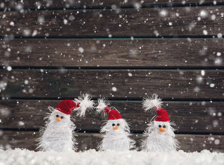 little snowmans on soft snow on rustic backgroundの写真素材