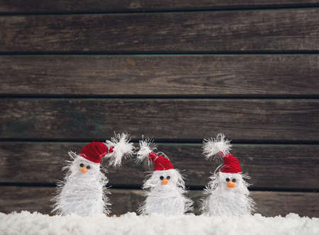 little snowmans on soft snow on rustic backgroundの写真素材