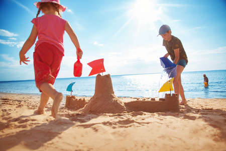 Boy and girl playing on the beachの写真素材