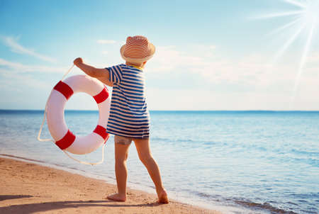 little boy playing at the beach in hatの写真素材