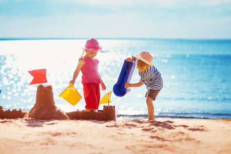 Boy and girl playing on the beachの写真素材