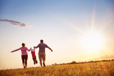 girl with mother and father holding hands on the natureの写真素材