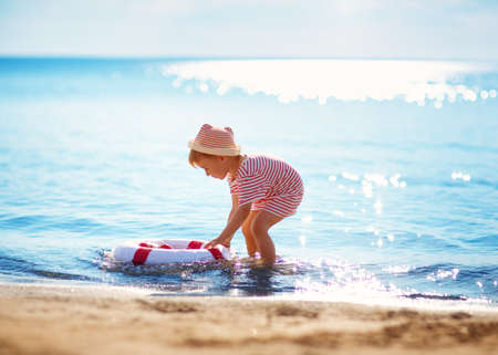 little boy playing at the beach in hatの写真素材