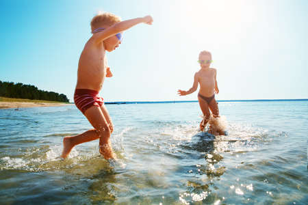 Boy and girl playing on the beachの写真素材
