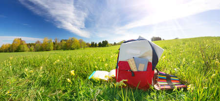 Colourful children schoolbag outdoors on the fieldの写真素材